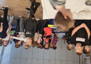 Dzieci stoją przy stacjach z wróżbami .