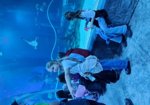 Dzieci przyglądają się rybą w akwarium.