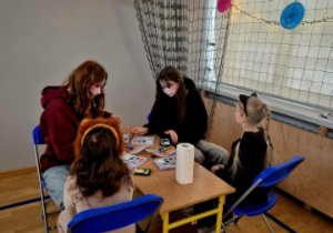 Dziewczyny z klasy 8 malują twarze dzieci.