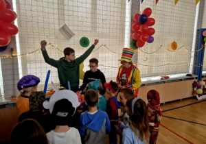 Chłopcy z klasy 7 oraz pani pedagog robią zwierzątka z balonów.