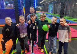 Grupa chłopców po meczu piłki nożnej na trampolinach.