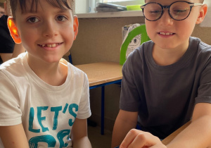 Dwje uczniowie prezentują model sztucznej szczęki.