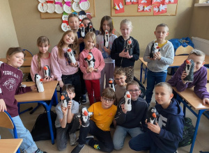 Uczniowie klasy 2 c prezentują własnoręcznie wykonane pingwiny z plastikowych butelek i bandaży.