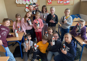 Uczniowie klasy 2 c prezentują własnoręcznie wykonane pingwiny z plastikowych butelek i bandaży.