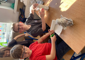 Uczeń wycina gipsowy bandaż.