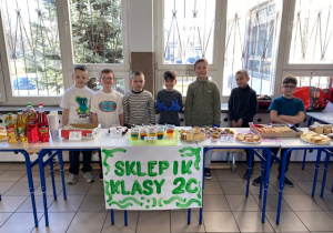 Chłopcy z klasy 2 c przy swoich stanowiskach pracy jako sprzedawcy.