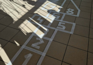 “Klasy” stworzone z białej taśmy malarskiej wraz z cyframi na parterze.