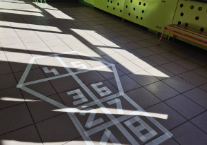 “Klasy” stworzone z białej taśmy malarskiej wraz z cyframi na 1 piętrze.