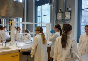 Uczniowie przygotowujący się do przeprowadzania doświadczeń w laboratorium chemicznym