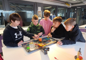 Uczniowie przeprowadzają eksperyment fizyczny.