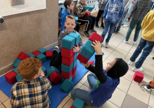 Trzech uczniów konstruuje budowlę z klocków magnetycznych.