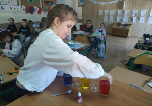 Uczennica podczas wykonywania eksperymentu „Wędrująca woda” .