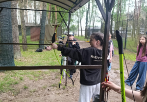 Uczennica klasy 5 strzela do celu z łuku.