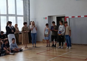 Laureaci szkolnego konkursu na najpiękniejszą Kartkę Wielkanocną na pamiątkowym zdjęciu z dyrekcją i nauczycielem koordynującym konkurs.
