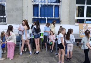 Kolorowe warkoczyki zaplatane uczniom na specjalnym stoisku w ramach szkolnych obchodów Dnia Dziecka.