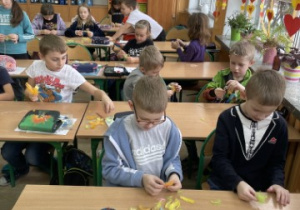 Uczniowie klasy 2 b tworzą z piórek zabawki dla kota