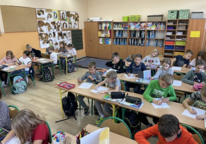 Uczniowie klasy 2 b kolorują portret kota Amadeusza