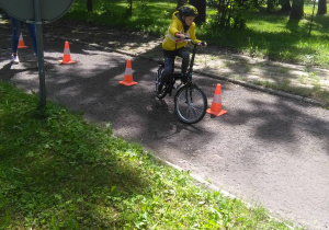 Uczeń pokonuje tor przeszkód na rowerze.