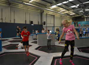 Uczniowie skaczą na małych trampolinach w parku trampolin Saltos