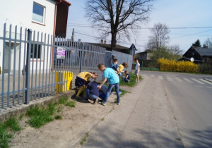 Uczniowie klas starszych porządkują teren wokół szkoły