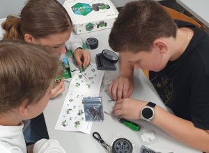 Troje uczniów montuje robota