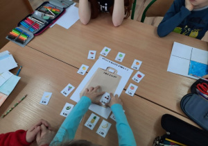 Uczniowie rozwiązują zagadkę matematyczną ćwiczącą dodawanie