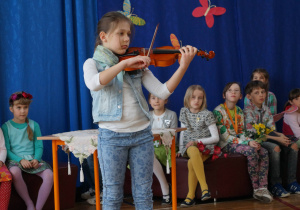 Uczennica gra na skrzypcach podczas Dnia Poezji