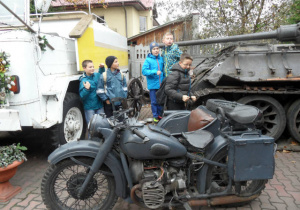 Pięciu uczniów ogląda motocykl