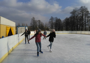 Uczennice jeżdżą na łyżwach na lodowisku