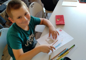 Uczeń wykonuje pracę plastyczną z wykorzystaniem kredek techniką połącz kropki