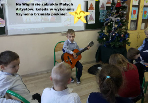 Uczeń gra na gitarze kolędę