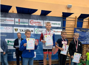Zwycięzcy zawodów sportowych z dyplomami i medalami na podium