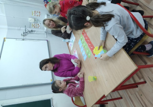 Trzy uczennice z klas pierwszych, wraz ze swoimi mamami grają w karcianą grę „wyścig”.