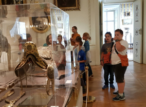 Uczniowie zwiedzają muzeum w Nieborowie, oglądają bogato zdobione siodło w gablocie