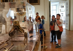 Uczniowie zwiedzają muzeum w Nieborowie, oglądają bogato zdobione siodło w gablocie