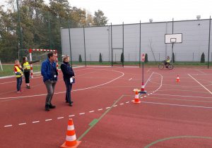 Uczennica jedzie na rowerze po boisku szkolnym