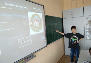 Uczeń klasy 6b notuje wyniki quizu na zielonej tablicy