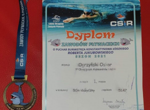 Dyplom uznania i medal zdobyty przez Oskara w zawodach pływackich.