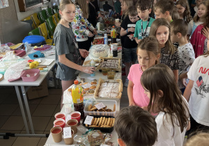 Uczniowie kupuja smakołyki podczas kiermaszu szkolnego