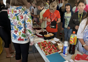 Uczniowie kupuja smakołyki podczas kiermaszu szkolnego