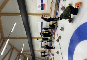 Uczniowie grają rozgrywki w mini curling